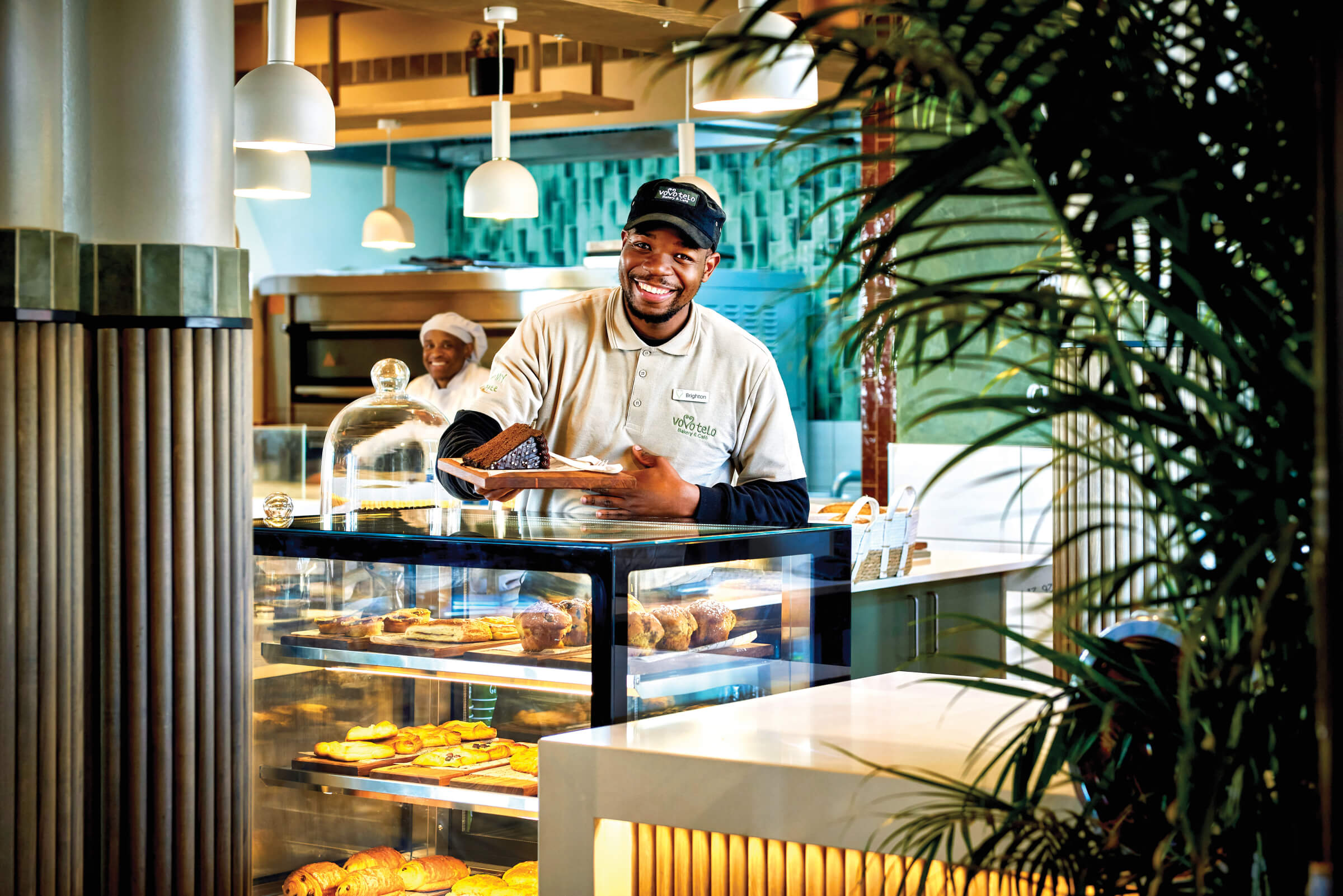 A smiling Vovo Telo baker at the pastry counter